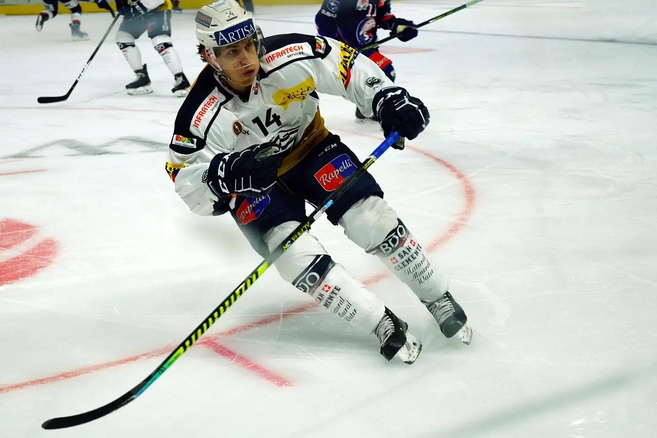 Ishockeyspiller kontrollerer pucken på isen