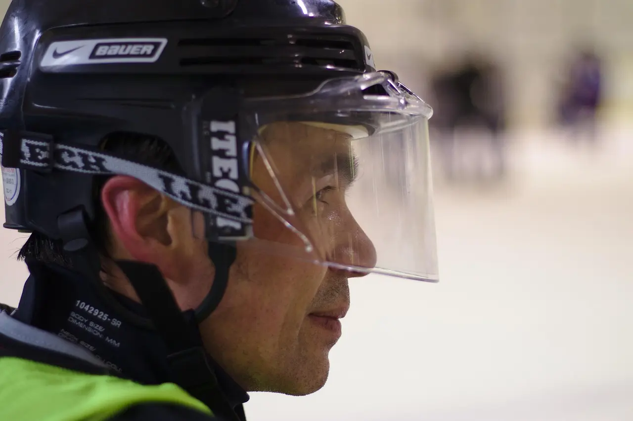 Ishockeyspiller i profil med hjelm og visir